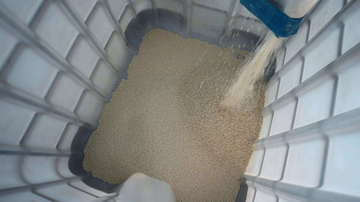 リサイクル工場で作られる樹脂ペレットが注がれる様子