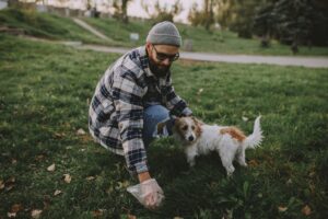散歩中に犬の排せつ物を拾う飼い主